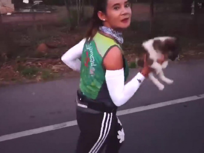 女选手抱著小狗跑了19英里，成功到达终点线，令人难以置信。（网图）
