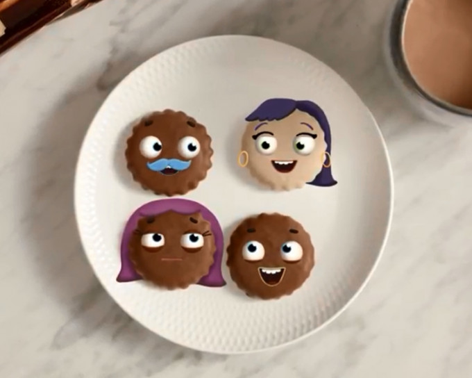 廣告中出現4塊人臉餅乾，其中一塊是白色的，其餘3塊是深啡色的。片段截圖