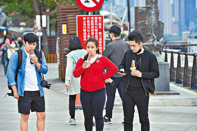 台湾淡水游客未惧疫情，在码头享用冰淇淋。