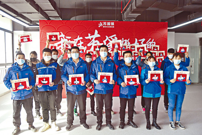 浙江义乌企业为留下过年的员工拍照，寄回家乡。