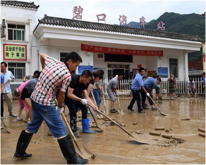 市民合力清理街道上的淤泥。 新華社