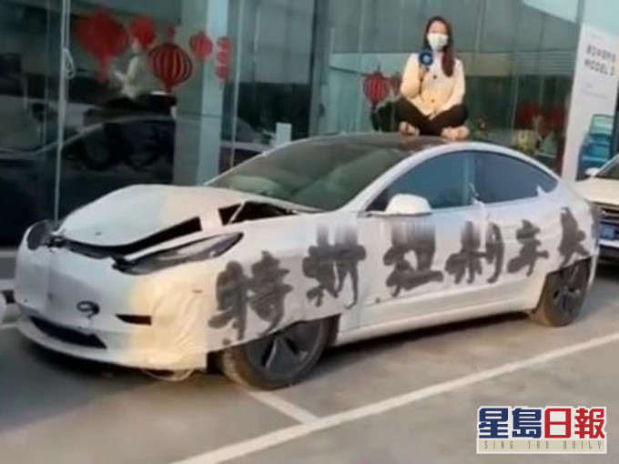 特斯拉女车主坐车顶维权,指刹车失灵,引发交通事故,一家四口险些丧命。(网图)