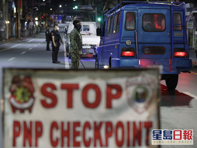 马尼拉宵禁实施后,多名警察到大马尼拉地区的检查站,检查司机的证件。AP图片