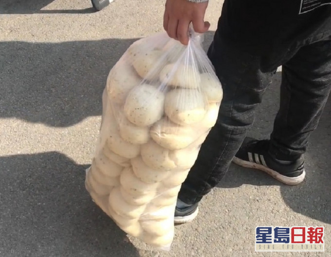 西安一名男子手提60多個饅頭。網圖