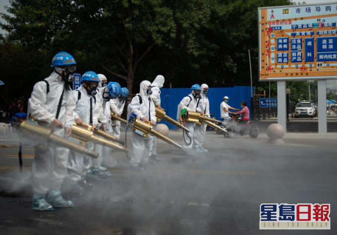 北京藍天救援隊隊員在岳各莊批發市場展開消毒工作。(新華社圖片)