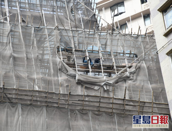 兩名工人一度坐在棚架上。