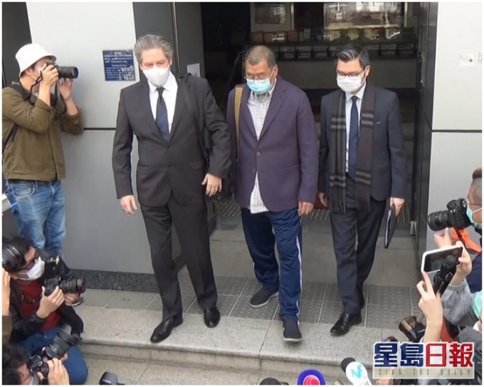 被捕的黎智英(中)下午1時前,戴著口罩離開九龍城警署。