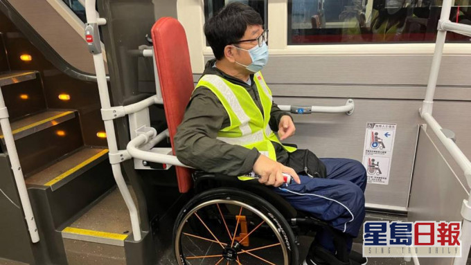 香港復康力量董事伍強試用新的扶手,認為新設施可以保護輪椅乘客。九巴圖片