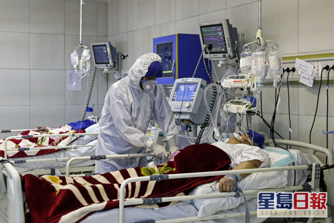 一名醫護在伊朗德黑蘭醫院治療一名染疫患者。 AP