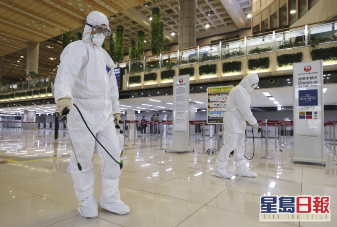 穿著防护服的工作人员在南韩首尔金浦机场喷洒消毒剂,以预防新冠状病毒。AP