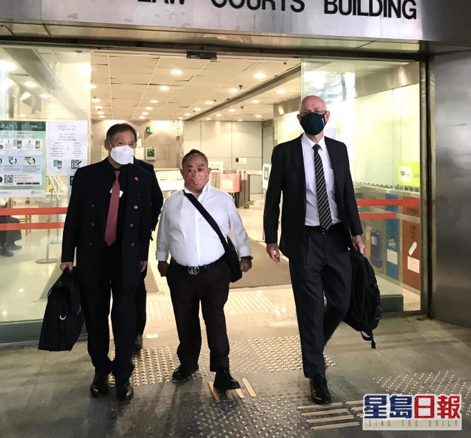 被告胡炳雄(中)、代表大律師戴偉奧(右)。