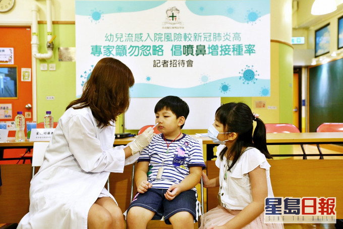 药剂师示范为幼儿接种喷鼻式流感疫苗。