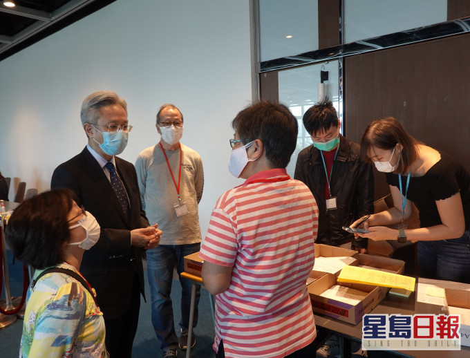 罗智光(左二)今日到访政府资讯科技总监办公室位于香港大会堂的家居检疫控制中心,关心同事应对强制家居检疫人数增加的工作情况。 政府图片