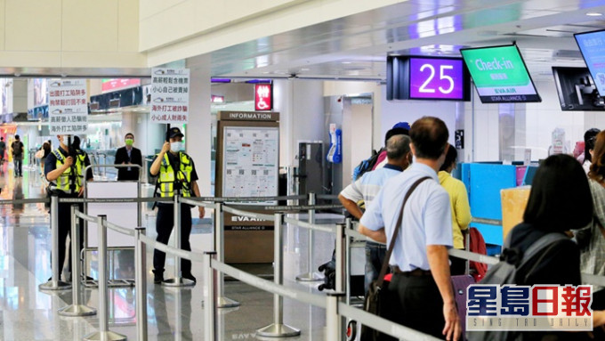 台灣近日出現誘騙民眾到柬埔寨的求職陷阱，警員要在機場舉牌提醒出境人士防範。中時圖片