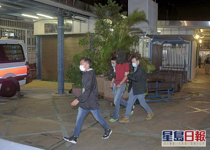 身穿红衣的疑凶蔡南生,昨晚在南丫岛落网后由多名人员押走。