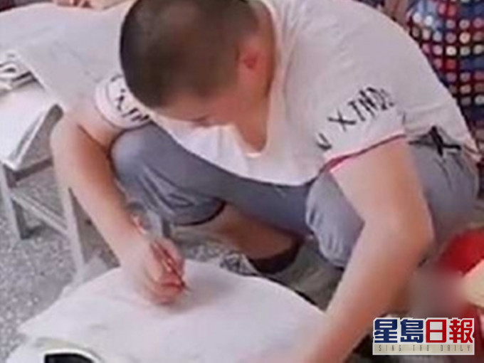 有學學生用書包當桌子做暑期作業。網圖
