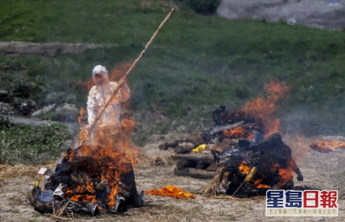尼泊尔火葬场爆满,工作人员在庙宇旁焚烧新冠患者遗体。AP图片