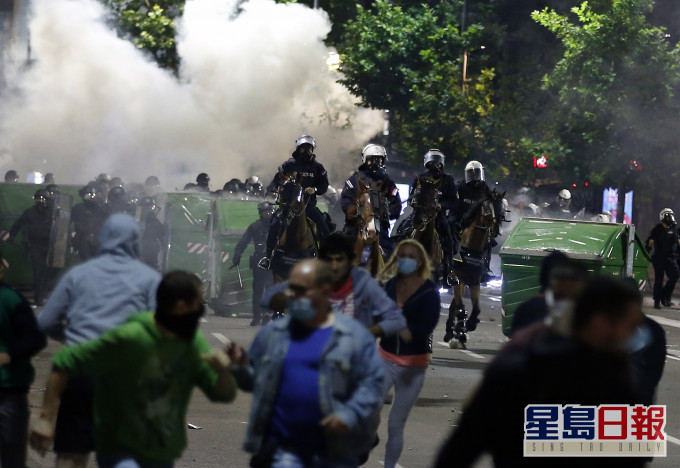 塞爾維亞示威者衝擊國會大樓,防暴警察施放催淚彈驅散。 AP