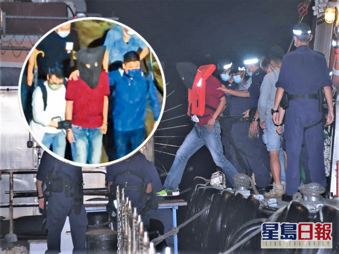 身穿红衣的疑凶蔡南生,昨晚在南丫岛落网后由多名人员押走。