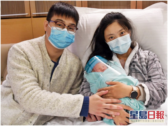 元旦B女戴上面罩,在父母懷內與傳媒見面。