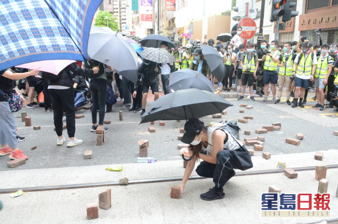 示威者投掷砖头杂物出路面。