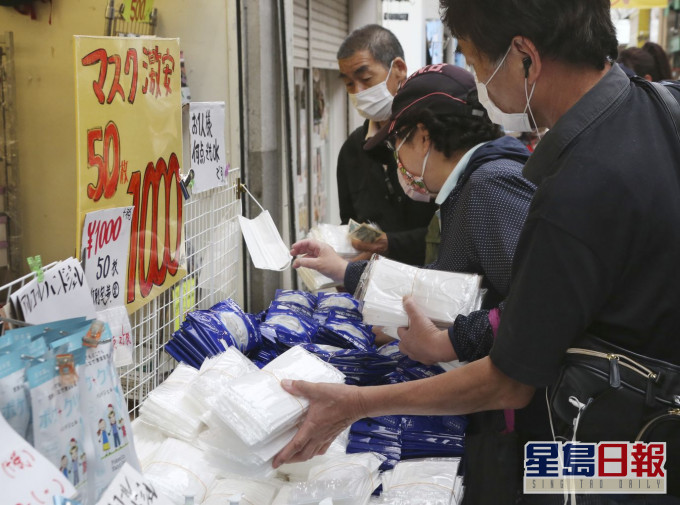 在新冠疫情下,日本民众选购口罩等物品。AP