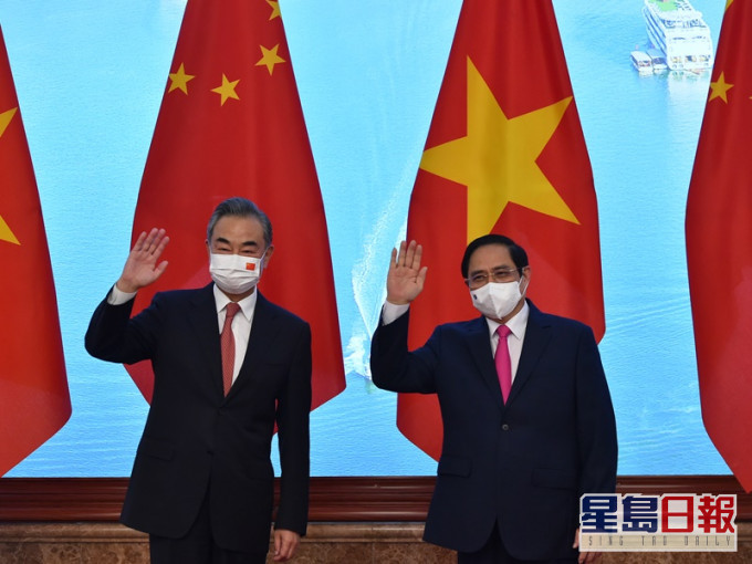 範明政(右)在河內會見王毅。新華社
