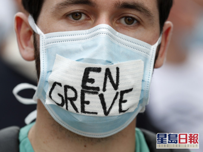 示威者在口罩上寫上罷工，他們要求改善醫護人員的薪金，以及對公立醫院投放更多資源。AP圖