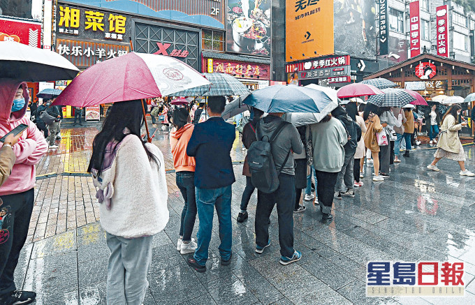 長沙一家奶茶店,數百年輕人冒雨排隊。