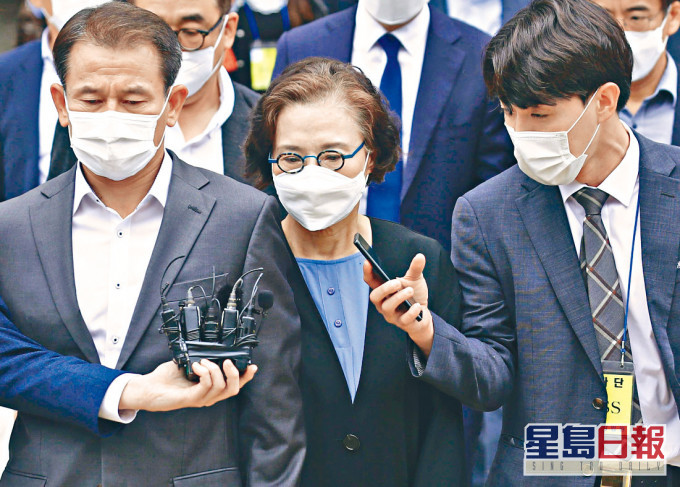 李明姬(中)周二在首爾中央地院聽判後離開法庭。