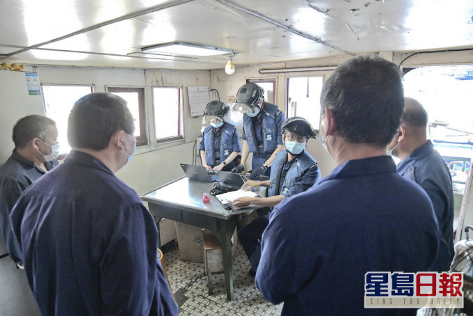 入境處船隻搜查小組多名隊員登上一艘外地躉船,根據申報船員名單逐一檢查,以防有人違法防疫法例偷偷登岸。 梁譽東攝