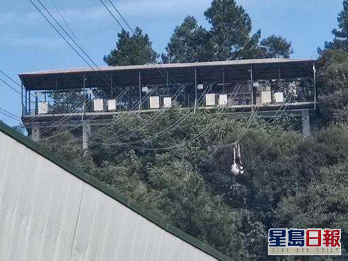 女子坐在高空索道的座椅上拍摄影片,突然座椅翻转。网图
