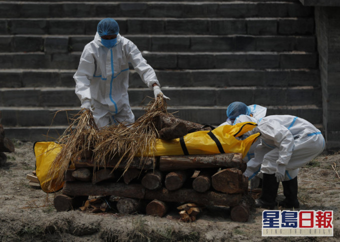 尼泊尔火葬场爆满,工作人员在庙宇旁焚烧新冠患者遗体。AP图片