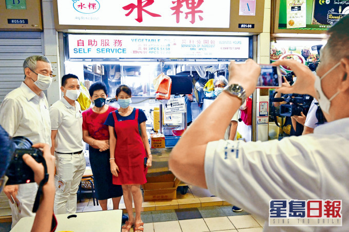 總理李顯龍（左）上周五落區為人民行動黨拉票時，與民眾合照。