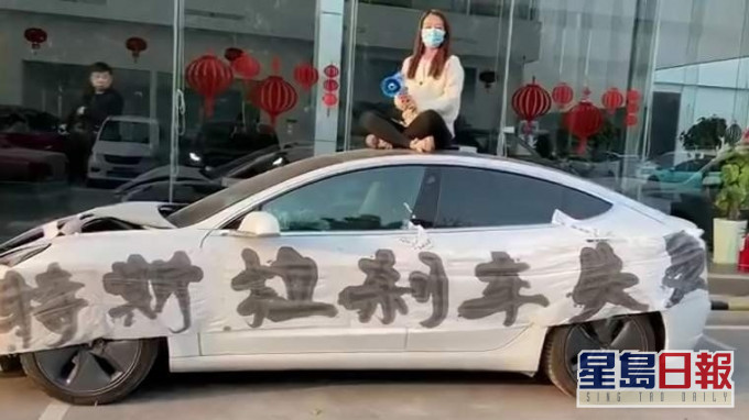 特斯拉女车主坐车顶维权。(网图)