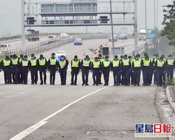 警員一字排開低頭搜索。