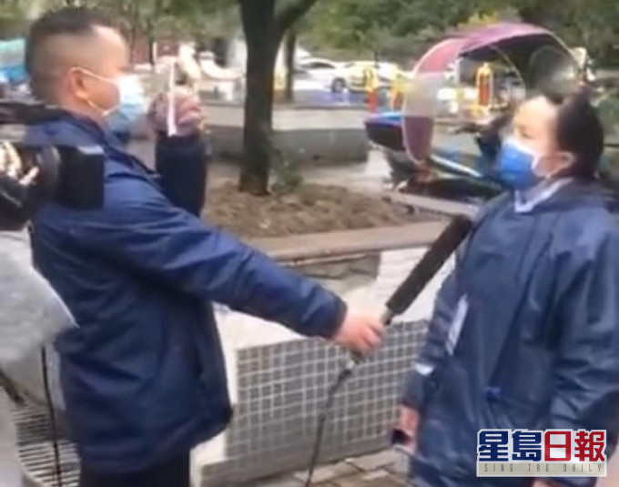 视频中的女社区工作人员接受采访时,有工作员拿著疑似采访稿给她照读。网图