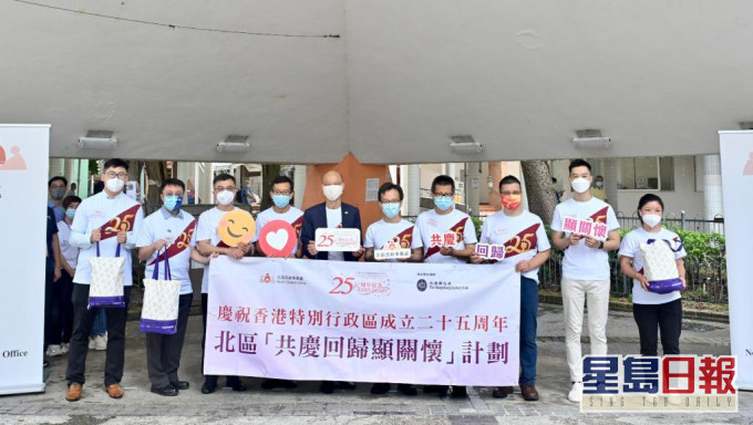 黃錦星（左五）今日參與「共慶回歸顯關懷」計劃的家訪活動。 政府圖片