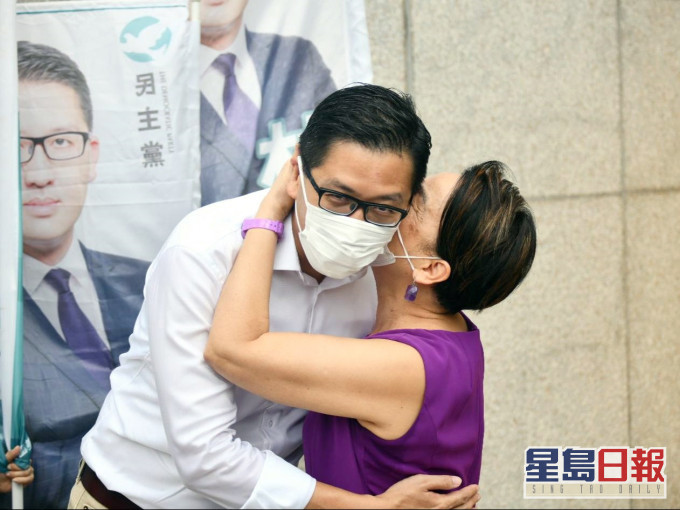 刘慧卿隔著口罩亲吻林卓廷脸颊。