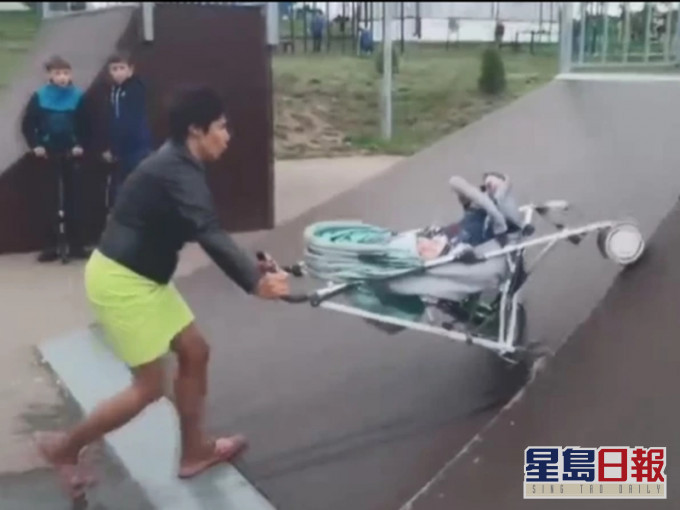 這名媽媽把嬰兒車當作滑板。網圖