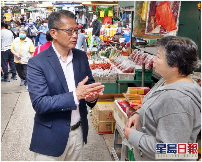 陳茂波(左)到街市、排檔和茶餐廳與市民聊天,聽他們對《預算案》的意見。