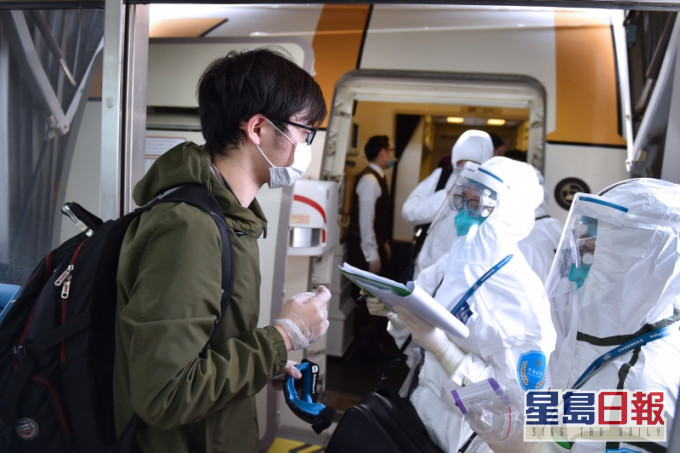 海关工作人员在飞机舱门处对入境人员相关情况进行询问、记录。(新华社)