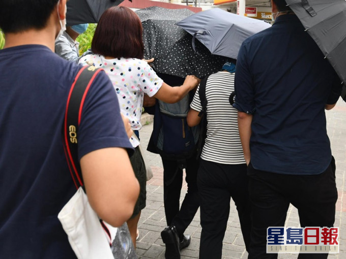 吳智晉在多人掩護下離開法院。