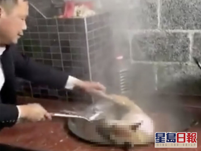 一名大叔不斷以熱水淋向鍋中的狗狗,狗狗不斷痛苦掙扎。(網圖)