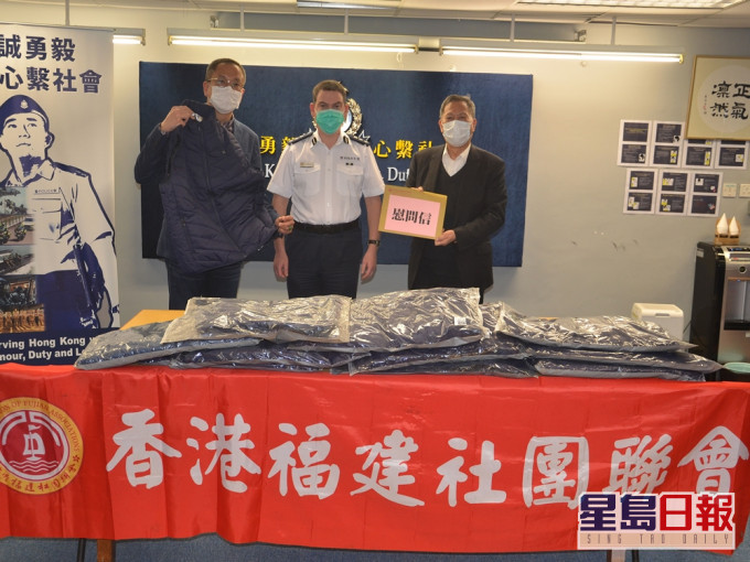 香港福建社團聯會主席吳換炎(右)及副主席兼秘書長施荣忻向將軍澳警區指揮官顏鐵誠致送慰問信及羽绒背心。