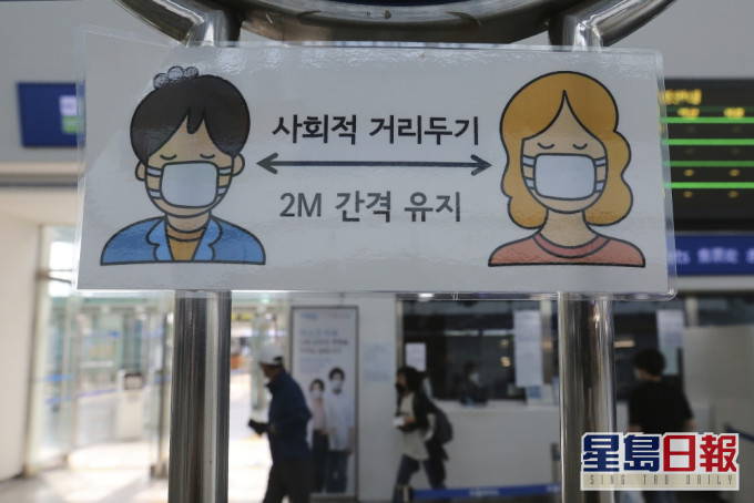 南韓宣傳載口罩及保持社交距離的橫額。AP圖