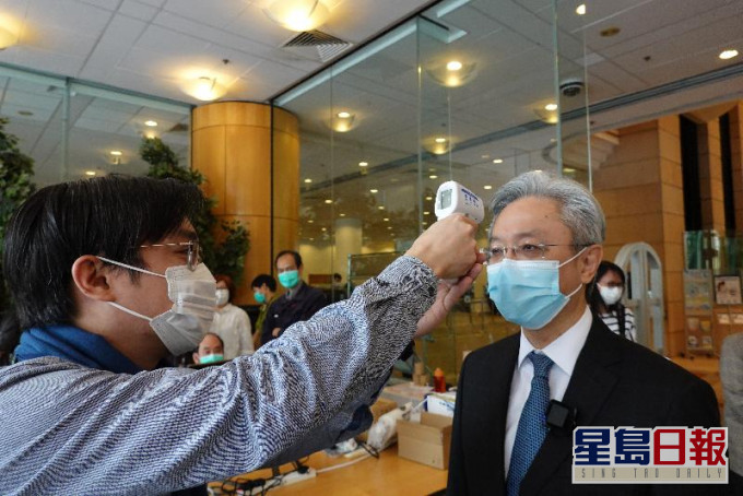 罗智光进入香港中央图书馆前接受体温检测。政府新闻处