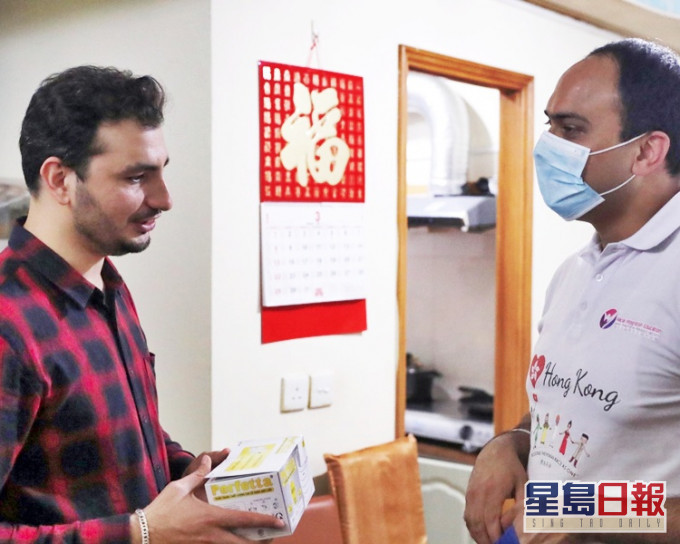 「同理心」白俊達(右)將華懋捐贈的口罩送給Khan一家。