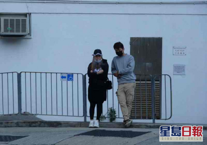 兩名男女親友倚在欄杆前神情黯然。