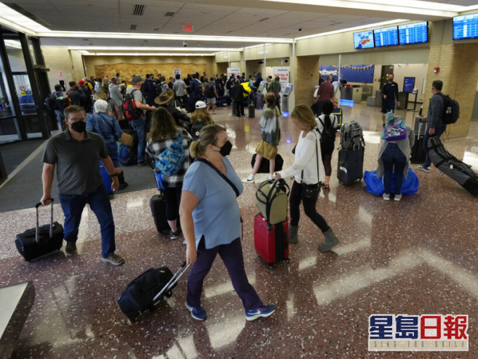 大批旅客在機場向票務職員查詢航班最新情況。AP圖片